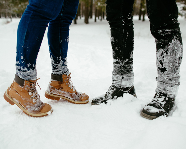 botas de una pareja de chico y chica pisando la nieve