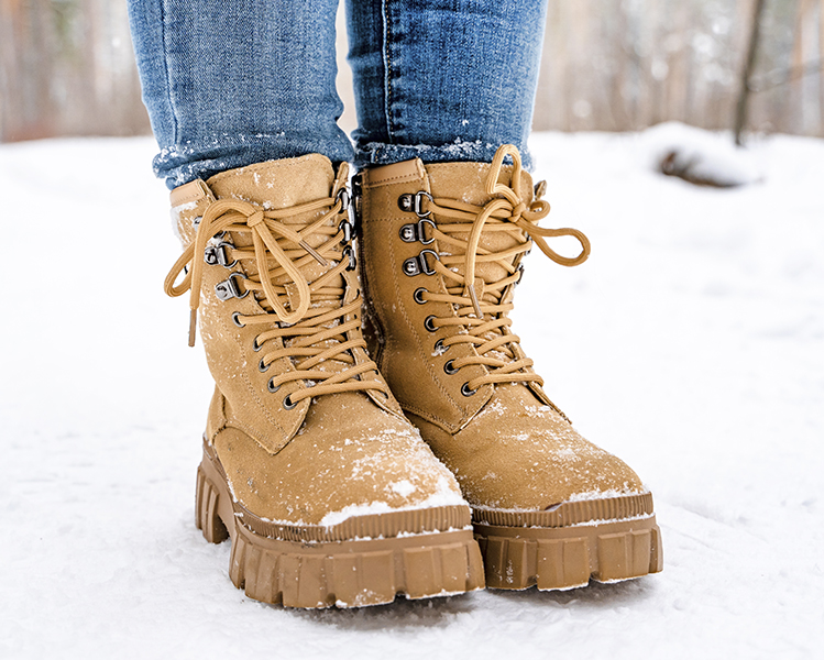 Botas marrones de mujer con el suelo de nieve