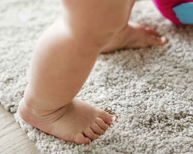 pies de bebe caminando sobre alfombra