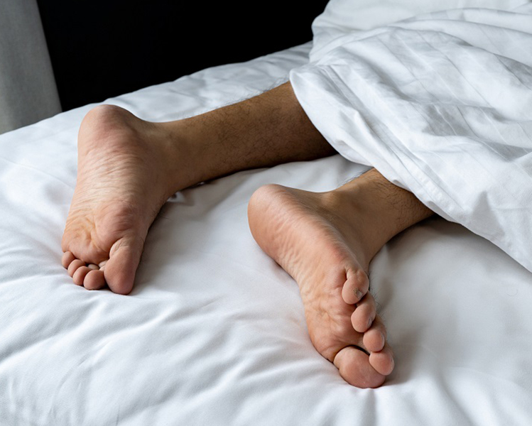 Pies descalzos sobre la cama