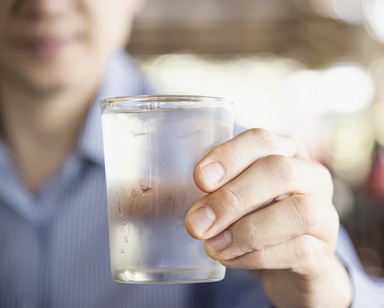 Man holding a glass of water with his hand