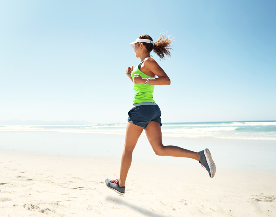 Mujer corriendo en verano por la playa