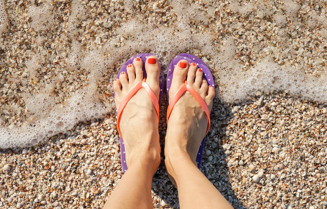 Chanclas a la orilla del mar en época de verano