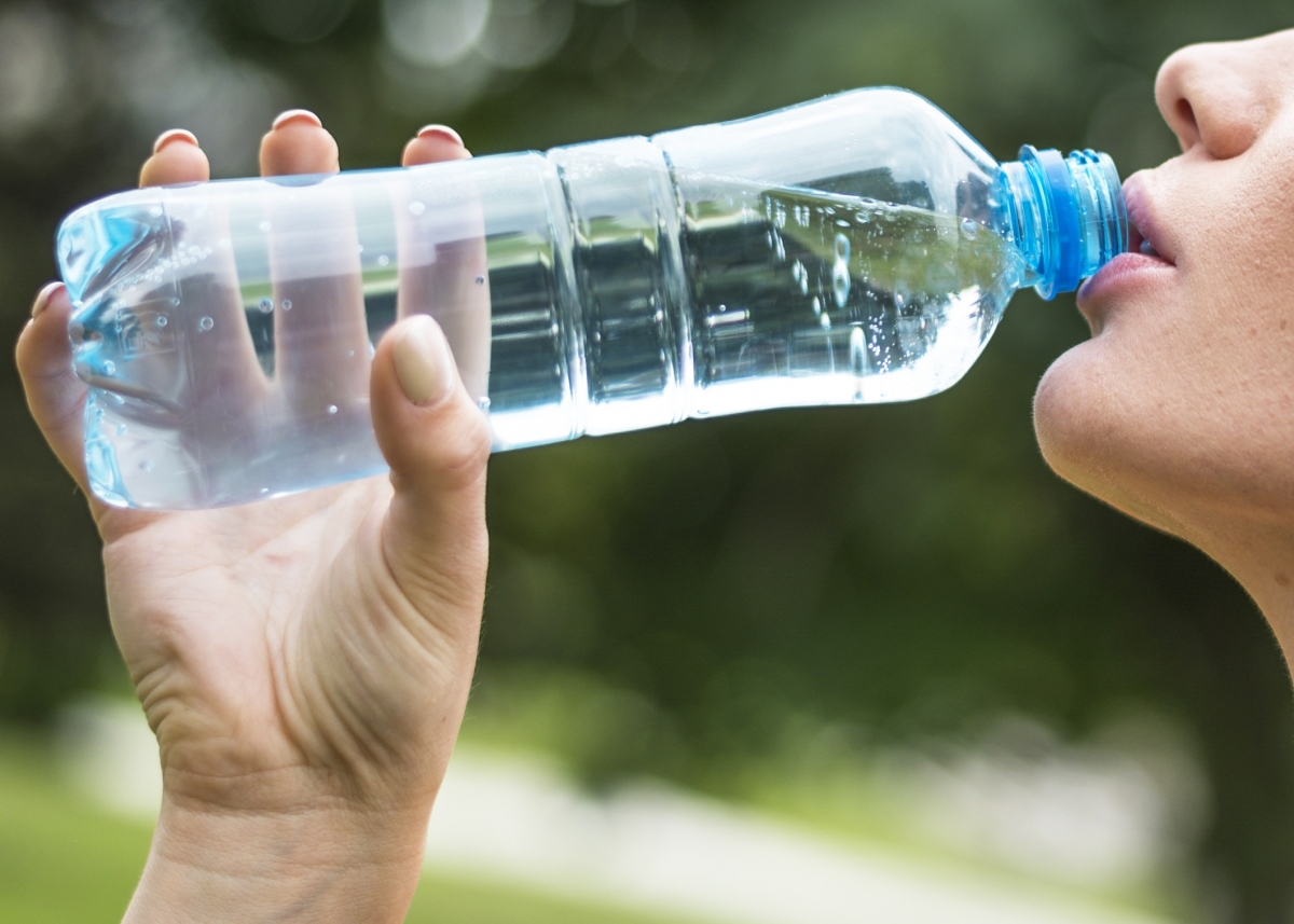 Mujer bebiendo agua de una botella pequeña